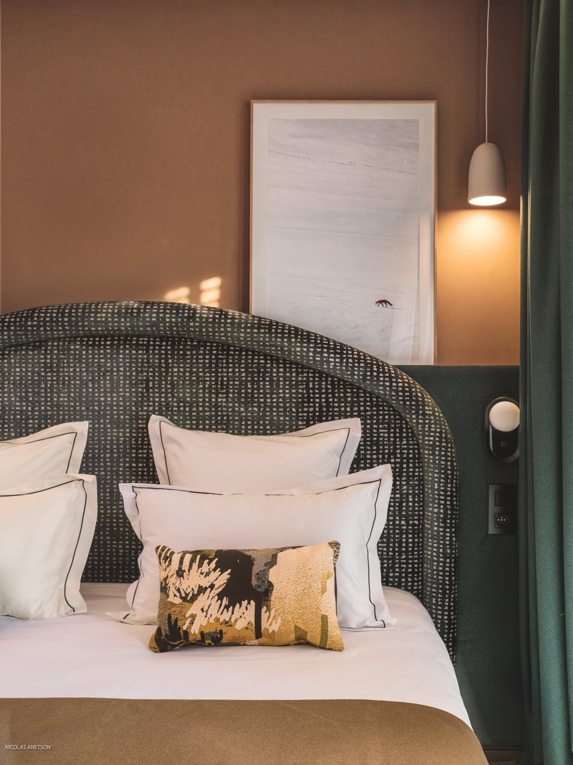 Tête de lit tressée et coussins brodés dans une chambre de Bârma