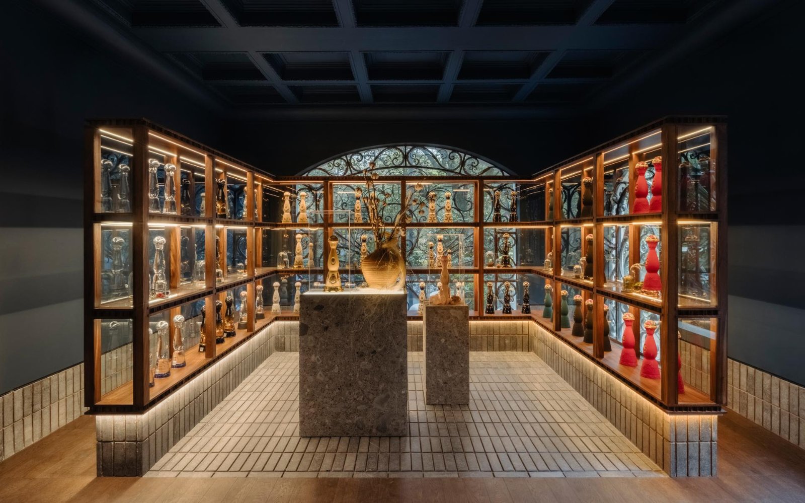 Salle d’exposition avec vitrines éclairées de décanteurs Clase Azul en céramique