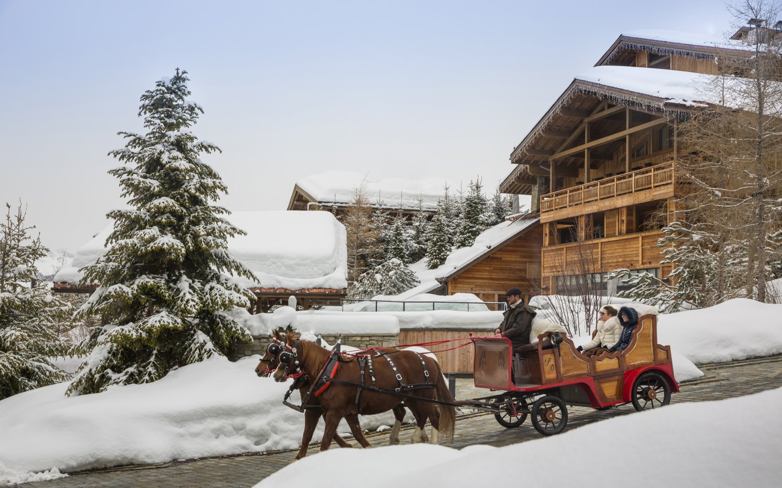 Promenade en traîneau à cheval devant les chalets du Four Seasons Resort Megève