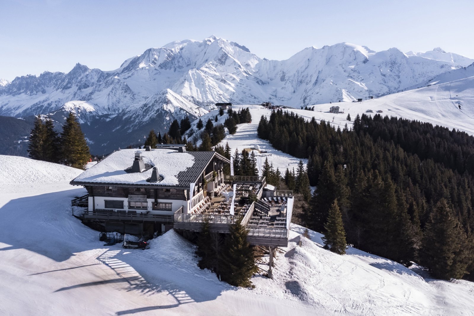 Le Four Seasons Resort Megève sous la neige, face aux sommets
