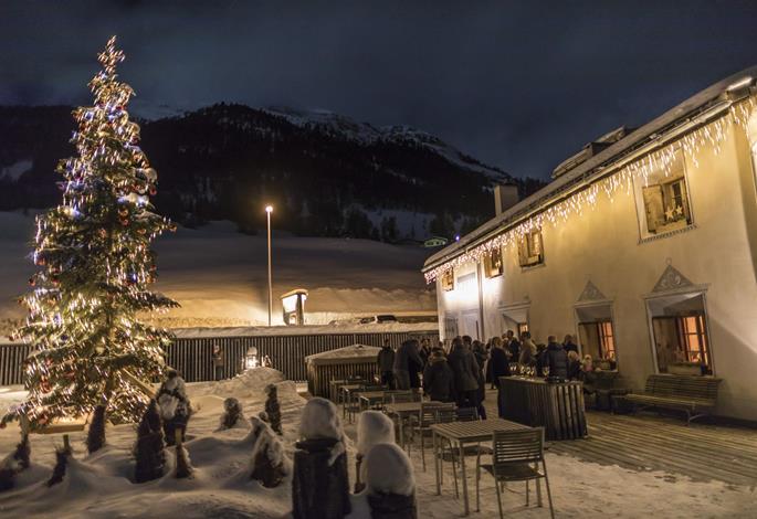 Sapin illuminé devant l’In Lain Hotel Cadonau sous la neige, en Engadine