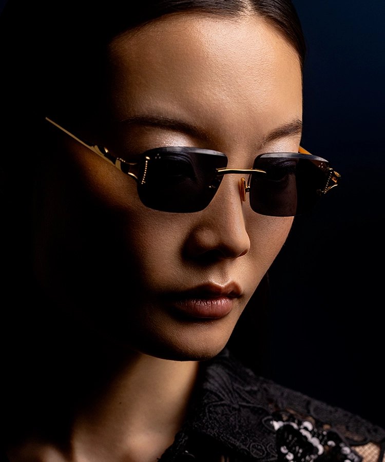 Portrait d’une femme portant des lunettes de soleil IRON Paris sur fond sombre