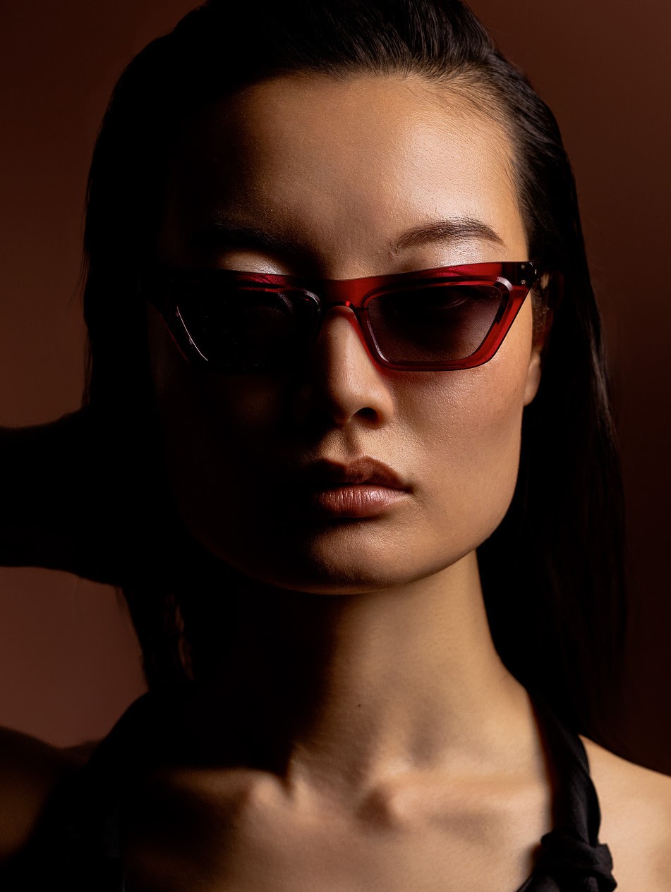 Femme portant des lunettes de soleil cat-eye rouges IRON Paris