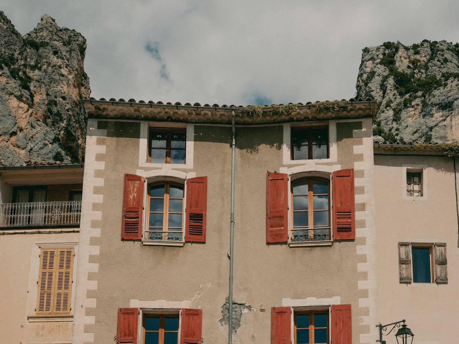 Maisons provençales aux volets rouges au pied des collines