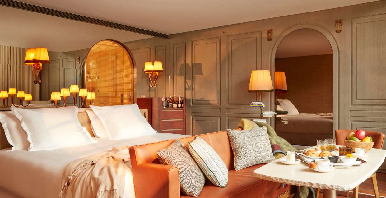 Chambre du Mondrian Bordeaux Les Carmes avec murs moulurés, lampes dorées et petit-déjeuner servi au lit