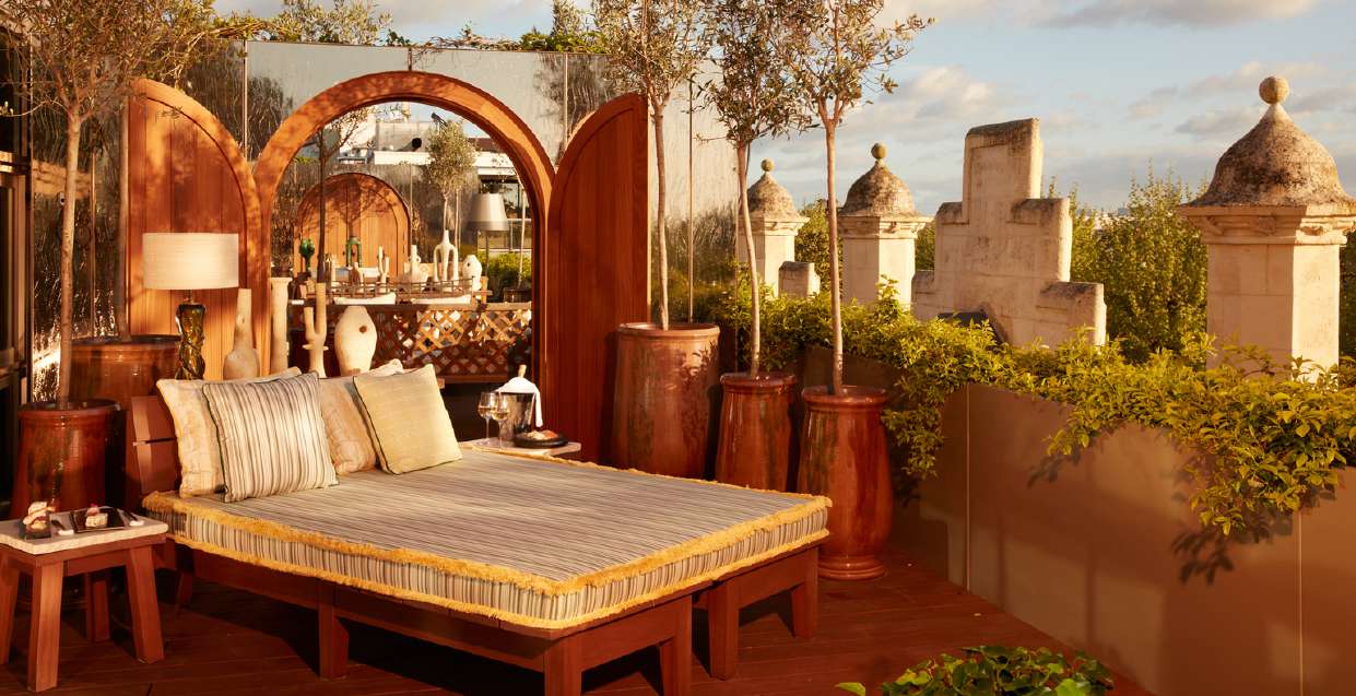 Terrasse privée végétalisée d’une suite rooftop du Mondrian Bordeaux, avec lit de jour et vue sur les toits