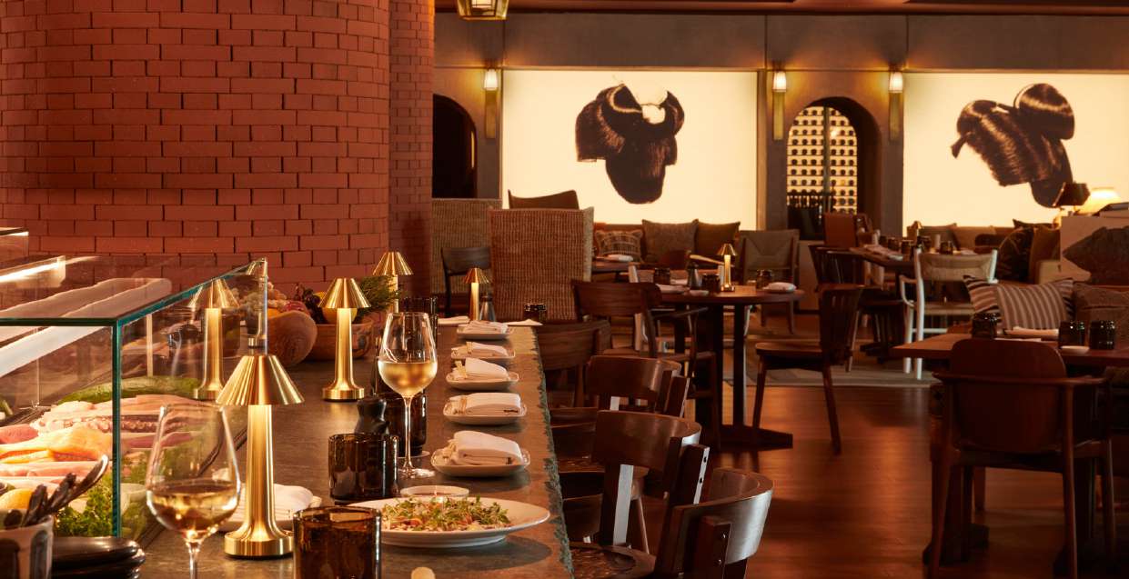 Salle du restaurant Morimoto Bordeaux avec colonnes en brique rouge et œuvres d’art japonaises