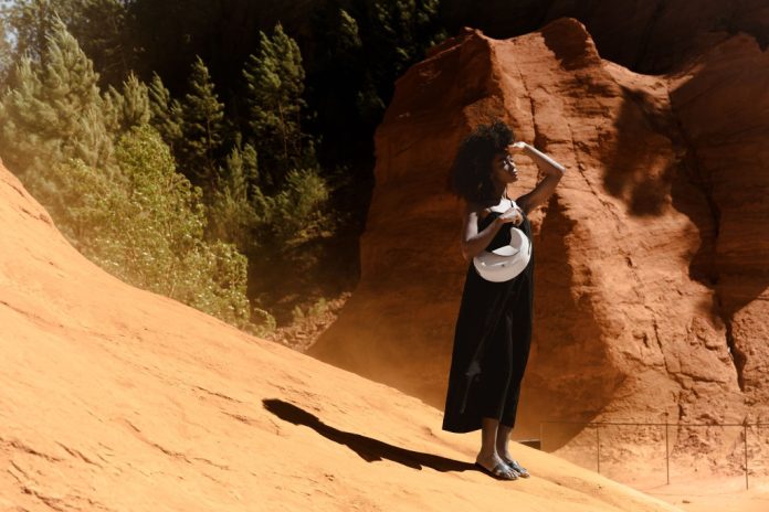 Femme portant le sac Nouvelle Lune de Nodie’s dans un paysage d’ocres rouges