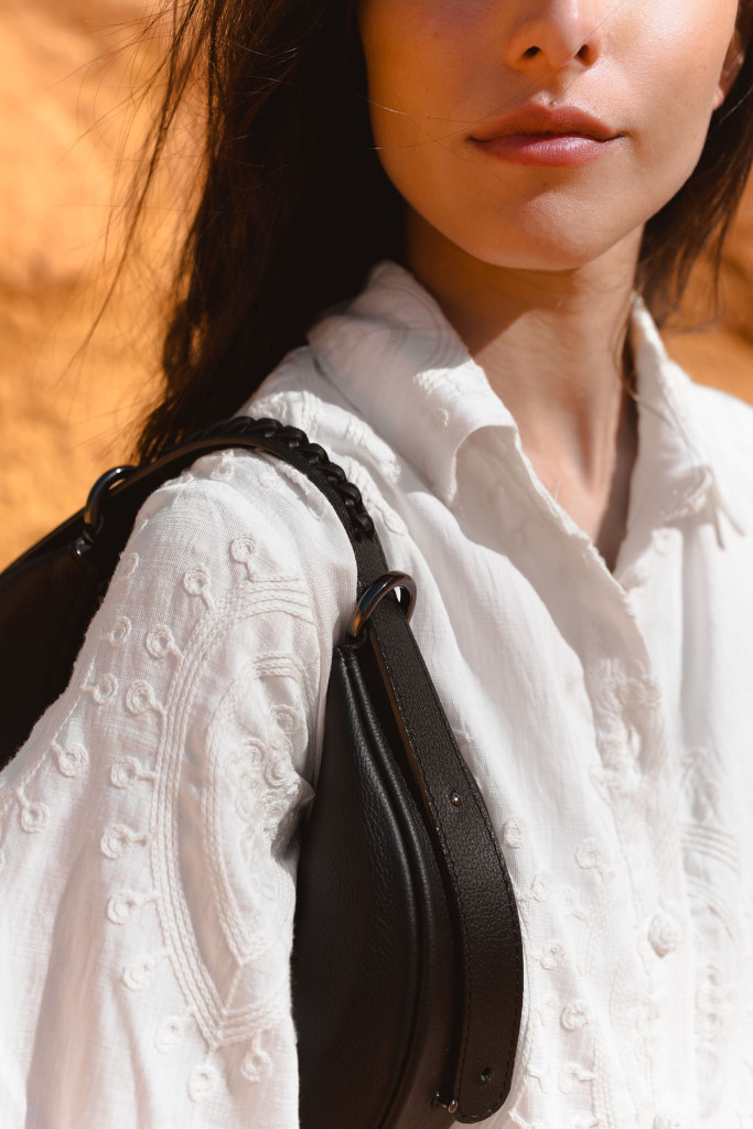 Sac Nouvelle Lune noir de Nodie’s porté à l’épaule sur une chemise blanche