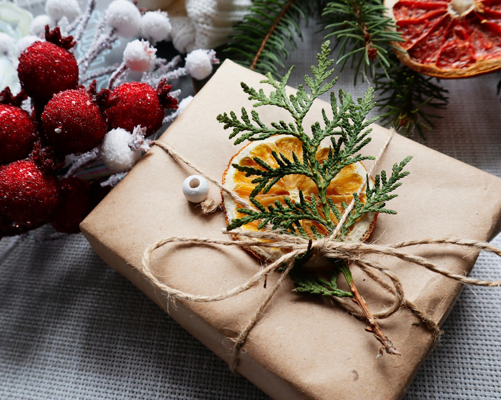 Paquet cadeau de Noël en papier kraft décoré d'oranges séchées