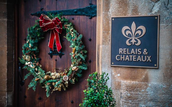 Couronne de Noël sur la porte en bois de Thornbury Castle à côté de la plaque Relais & Châteaux
