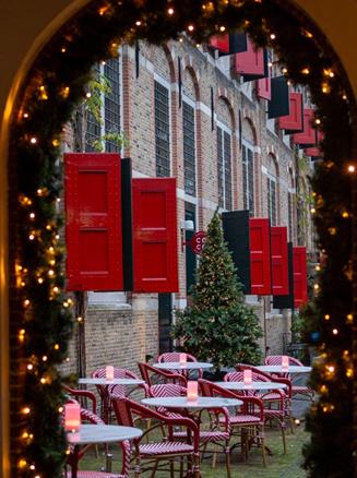 Façade de Weeshuis Gouda décorée pour les fêtes avec terrasse et drapeaux rouges